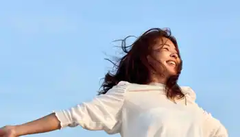 Una donna gioiosa che abbraccia il cielo